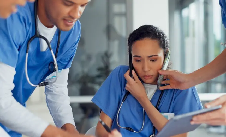 stressed clinicians with smartphone and computer