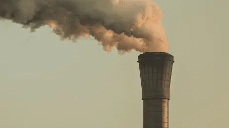 Smoke billowing from a factory tower
