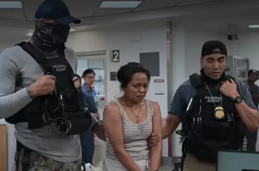 screenshot from the TV show the pitt. two large male agents drag a cuffed woman