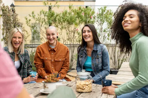 young women around a picnic table laughing