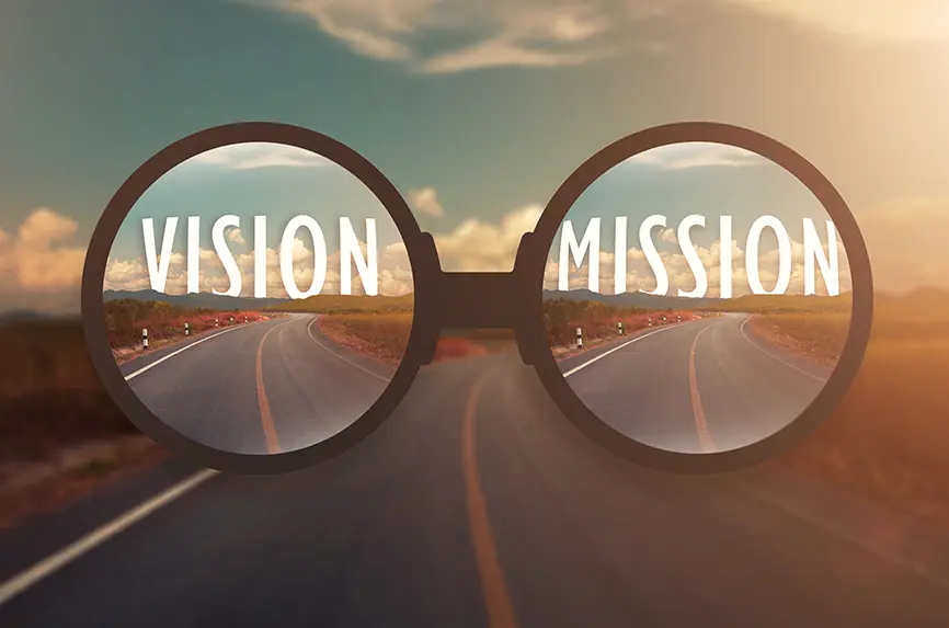 glass magnify against word VISION and MISSION behind the tree of empty asphalt road at golden sunset and beautiful blue sky. Concept for vision.