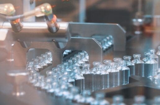 Glass bottles in production in the tray of an automatic liquid dispenser, a line for filling medicines against bacteria and viruses, antibiotics and vaccines