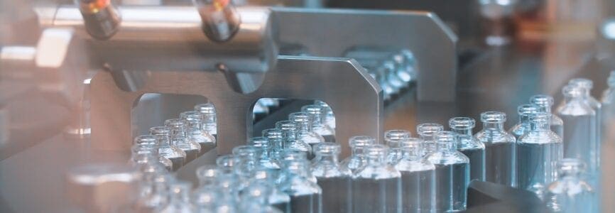 Glass bottles in production in the tray of an automatic liquid dispenser, a line for filling medicines against bacteria and viruses, antibiotics and vaccines