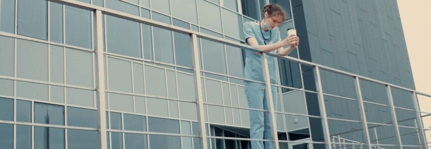 Portrait of tired exhausted nurse or doctor having a coffee break outside in the morning. COVID-19, Coronavirus pandemic. ARRI Alexa Mini