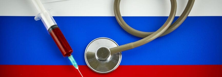 Stethoscope and syringe on Russia flag with coronavirus label