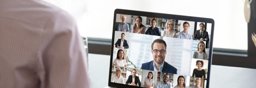 Multiracial people involved in group video call using modern tech videoconferencing application for study or business concept, view over businesswoman shoulder sitting at desk working with colleagues