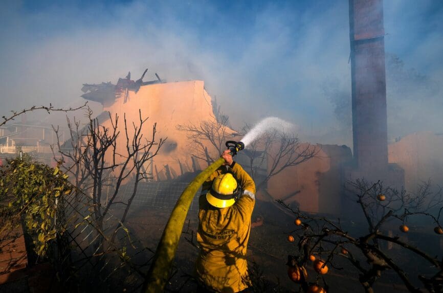 firefighter putting out a fire on a house