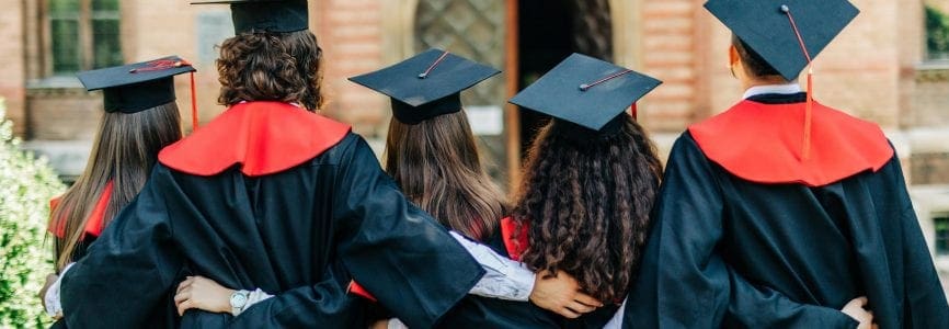 back view of college students with cap and gown celebrate graduation