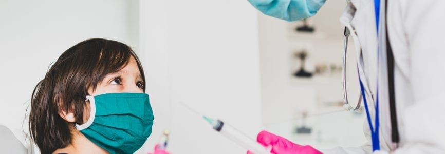 Little cute child with mask getting injection