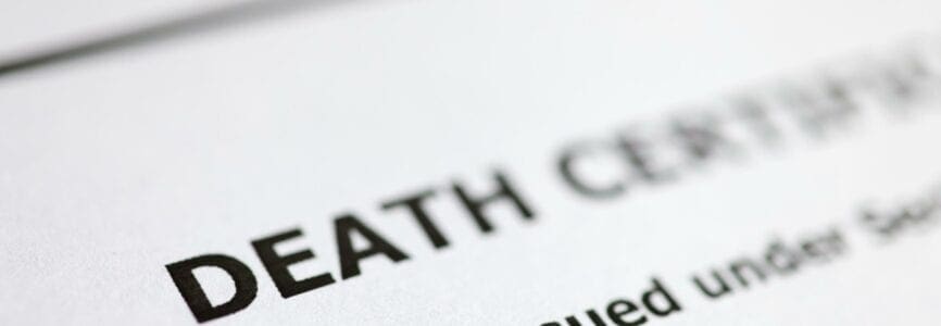 Death certificate is on table. Paperwork after death of relative concept