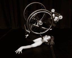 Alice Sheppard, in her wheelchair, rolls into a shoulder stand.