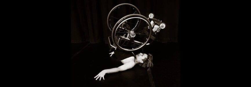 Alice Sheppard, in her wheelchair, rolls into a shoulder stand.