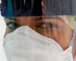 woman of color with a white mask and ear cover