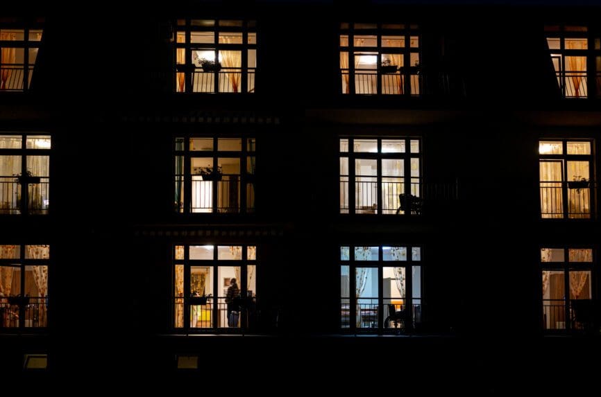 Illuminated windows of night house with people inside