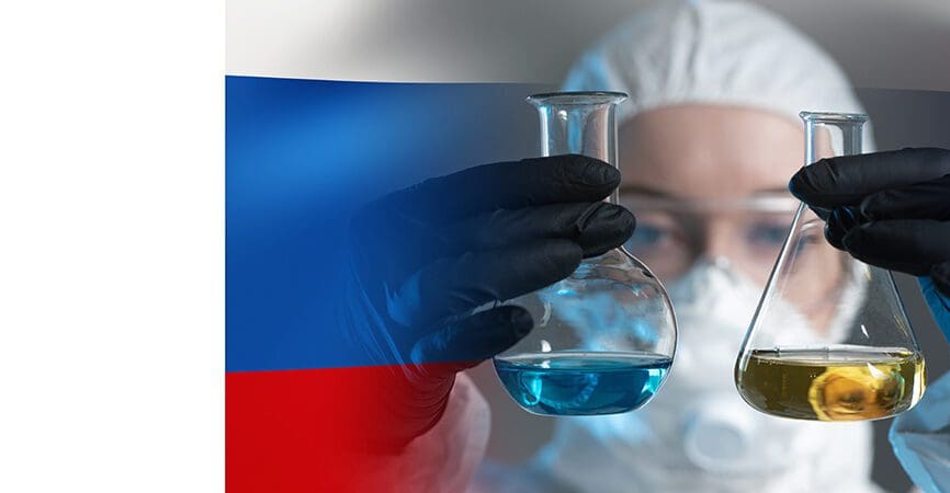 A scientist on the background of the Russian flag. Scientific research in Russia. A woman sets up a scientific experiment. A researcher in a protective suit. A scientist with two flasks in his hands.