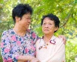 middle aged asian woman holding an older asian woman