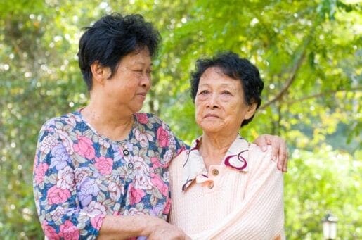 middle aged asian woman holding an older asian woman