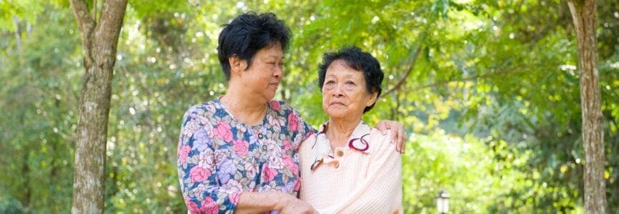 middle aged asian woman holding an older asian woman