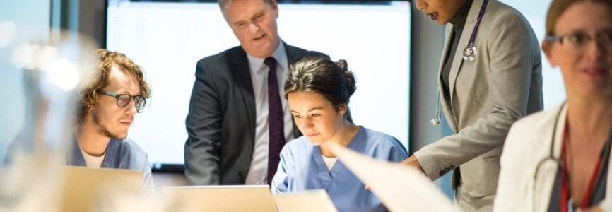 group of doctors sitting at a wooden table