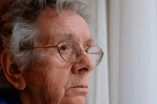 aging white man looking out a window