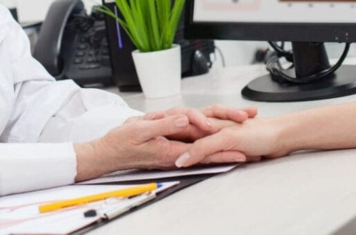 older pair of hands holding a young hand