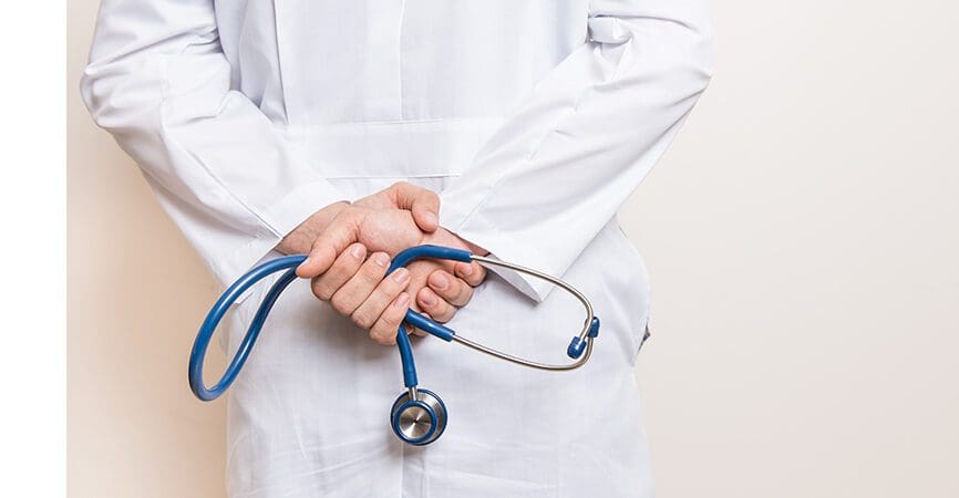 doctor with hands behind back holding stethoscope