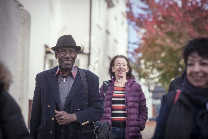 group of older smiling adults walking together in urban area