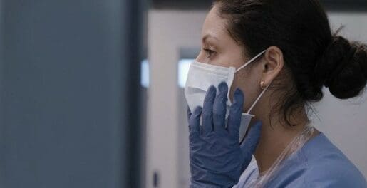 Female medical professional in mask and gloves.