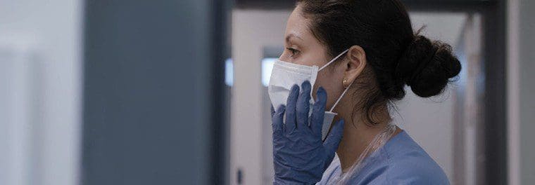 Female medical professional in mask and gloves.