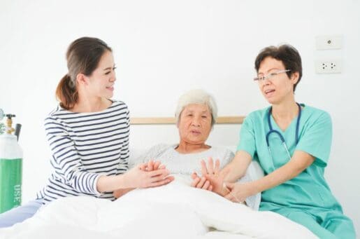 Asian nurse comforting older patient