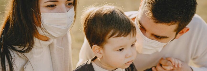 young white straight couple wearing masks with an unmasked baby