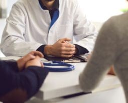 couple sitting at desk with doctor