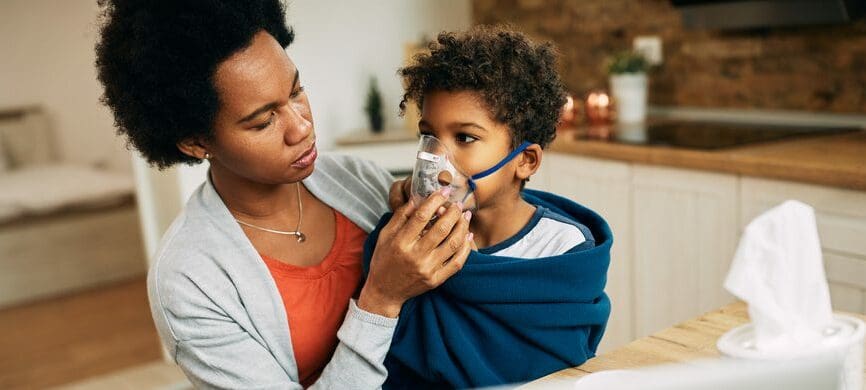 mom holding inhaler to child with asthma