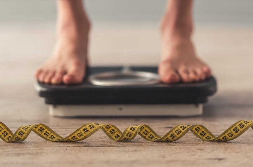 feet on scale, tape measure in front