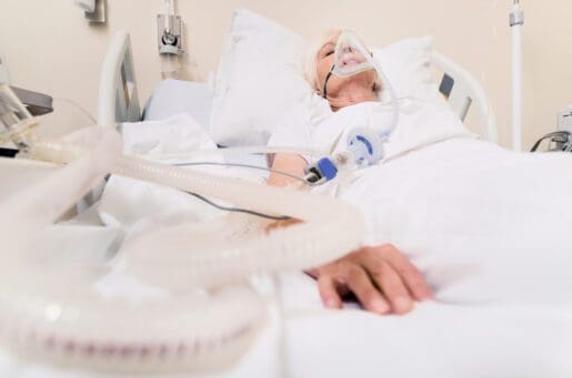 female patient in hospital bed on ventilator