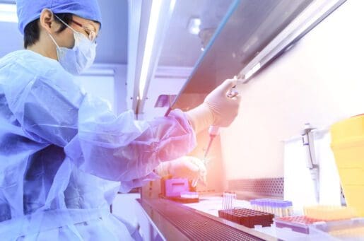 doctor using injection tube to put a bright light into a beaker