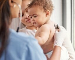 sick baby in nurse's arms