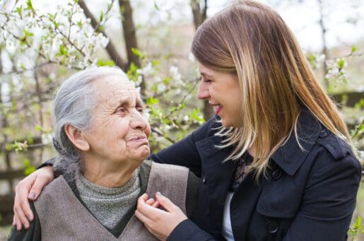 older hispanic woman smiles at younger blond woman