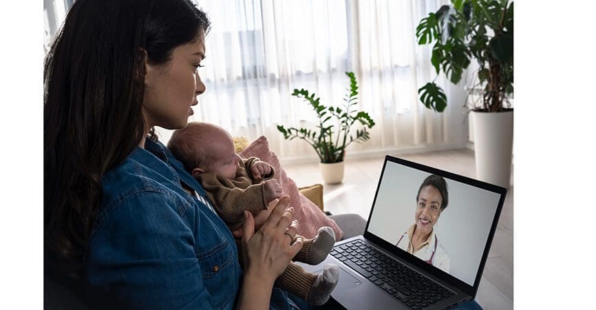 A young new mom is concerned about her baby's health, looking for doctors' advice online. Telemedicine. Ðžnline counseling with a pediatrician