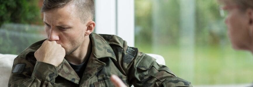 military man sitting by a window